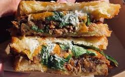 A hand hold two toasted sandwiches